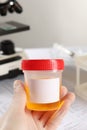 Nurse holding container with urine sample for analysis in laboratory, closeup Royalty Free Stock Photo