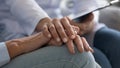 Nurse holding hand of elderly patient provides psychological support closeup