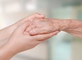 Nurse holding old patient hand