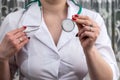 The nurse holds stethoscope in her hands