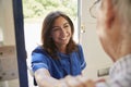 Nurse on home visit greeting senior man, over shoulder view Royalty Free Stock Photo