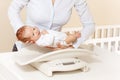 Nurse in hospital put little newborn baby on scale Royalty Free Stock Photo