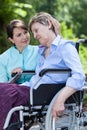 Nurse hugs an elderly disabled woman