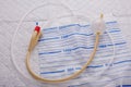 Nurse inflates urinary catheter bulb with leg drainage bag on sterile field.