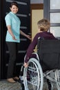 Nurse invites a disabled woman to the house Royalty Free Stock Photo