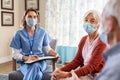 Nurse listening to senior couple during a home visit Royalty Free Stock Photo