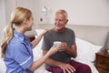 Nurse Making Home Visit To Senior Man In Bed Royalty Free Stock Photo