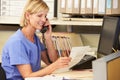 Nurse Making Phone Call At Nurses Station Royalty Free Stock Photo