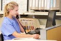 Nurse Making Phone Call At Nurses Station Royalty Free Stock Photo