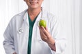 Nurse or male doctor giving an apple smiling. Health care concept isolated on white background. Royalty Free Stock Photo