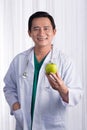 Nurse or male doctor giving an apple smiling. Health care concept on white background. Royalty Free Stock Photo