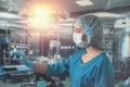 nurse in mask and gloves holding a syringe with medicine and waiting for a patient in surgery. Royalty Free Stock Photo