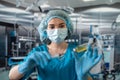 nurse in mask and gloves holding a syringe with medicine and waiting for a patient in surgery. Royalty Free Stock Photo