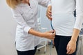 Nurse is meassuring the height of the pregnant girl`s stomack