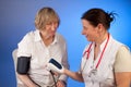 Nurse measures blood presssure of an elderly woman
