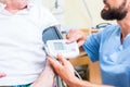 Nurse measuring blood pressure of senior patient Royalty Free Stock Photo