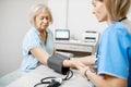 Nurse measuring blood pressure of a senior patient Royalty Free Stock Photo