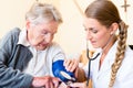 Nurse measuring blood pressure at senior patient Royalty Free Stock Photo