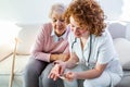 Nurse measuring blood sugar of senior woman at home. Young nurse measuring blood sugar of elderly woman at home. Doctor checking