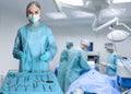 Nurse near table with different surgical instruments in operating room Royalty Free Stock Photo