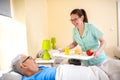 Nurse in a old peopleÃ¢â¬â¢s home providing residential care by bringing breakfast to her senior man occupant