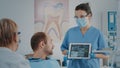 Nurse and patient analyzing denture radiography in dentistry cabinet