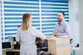 Nurse and patient conversing at reception desk in hospital Royalty Free Stock Photo