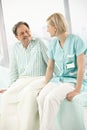 Nurse and patient sitting on bed