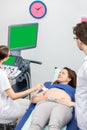 A nurse performs an ultrasound on a pregnant patient under the guidance of the attending doctor. Royalty Free Stock Photo