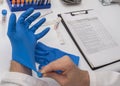 Nurse placing latex glove to analyze positive covid-19 test results of infected persons Royalty Free Stock Photo