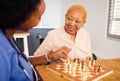 Nurse playing chess with a senior patient after a healthcare consultation in nursing rehabilitation center. Board game Royalty Free Stock Photo