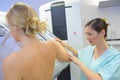 Nurse positioning patients arm during mammogram examination