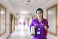 Nurse in purple uniform with backpack standing and holding book