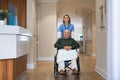 Nurse pushing senior man on a wheelchair at private clinic Royalty Free Stock Photo