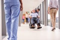 Nurse Pushing Senior Patient In Wheelchair Along Corridor Royalty Free Stock Photo