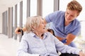 Nurse Pushing Senior Patient In Wheelchair Along Corridor Royalty Free Stock Photo