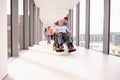 Nurse Pushing Senior Patient In Wheelchair Along Corridor Royalty Free Stock Photo