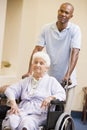 Nurse Pushing Senior Woman In Wheelchair