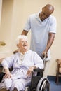 Nurse Pushing Senior Woman In Wheelchair