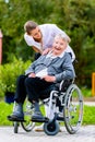 Nurse pushing senior woman in wheelchair on walk