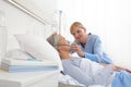 Nurse puts oxygen mask on elderly woman patient lying in the hospital room bed Royalty Free Stock Photo