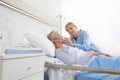 Nurse puts oxygen mask on elderly woman patient lying in the hospital room bed Royalty Free Stock Photo