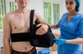 Nurse putting a sling on patients arm that is broken. Injury Royalty Free Stock Photo