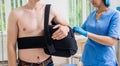 Nurse putting a sling on patients arm that is broken. Injury Royalty Free Stock Photo