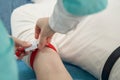 Nurse putting tourniquet on male arm in hospital