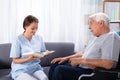 Nurse Reading Book For Disabled Senior Man Royalty Free Stock Photo