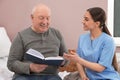 Nurse reading book with senior man in hospital ward Royalty Free Stock Photo