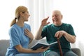 Nurse reading book to elderly man. Assisting senior people