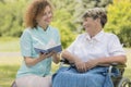 Nurse reading elderly woman in a garden Royalty Free Stock Photo