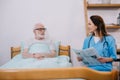 Nurse reading newspaper to senior Royalty Free Stock Photo